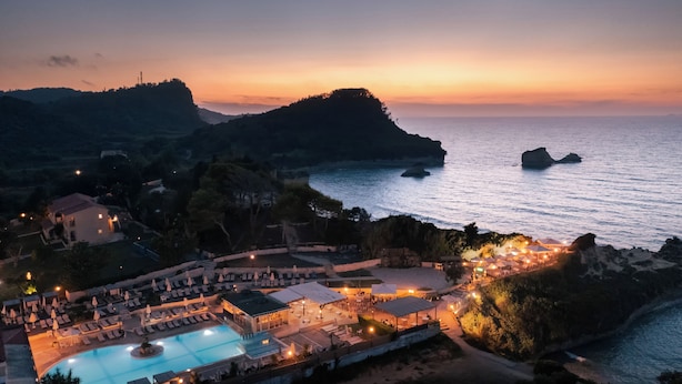A resort with a swimming pool, beachside lounge, and ocean views at sunset. - Akron Seascape Resort by Anayia All Inclusive Resorts (Corfu)