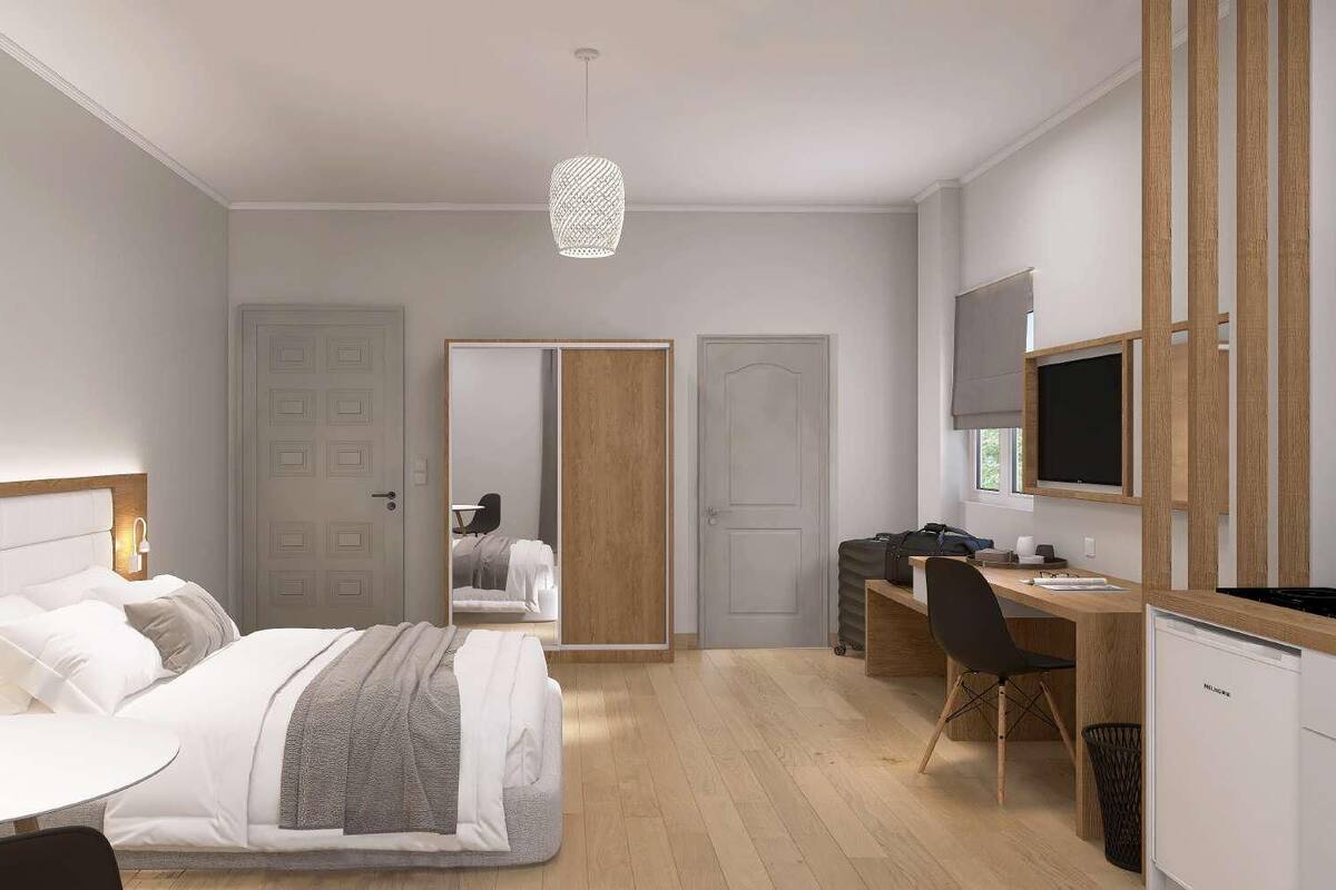 Een moderne hotelkamer met een bed, nachtkastje, bureau, stoel en een televisie.