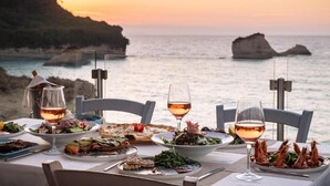 A table set for dinner with a view of the sea and cliffs. - Akron Seascape Resort by Anayia All Inclusive Resorts (Corfu)