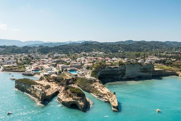 A coastal town with a prominent cliff formation, a marina, and a variety of buildings.