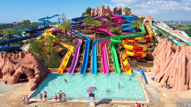 Un parc aquatique doté de nombreux toboggans colorés et d’un espace piscine central.