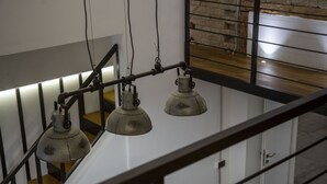 A staircase with a metal railing and three industrial-style pendant lights.