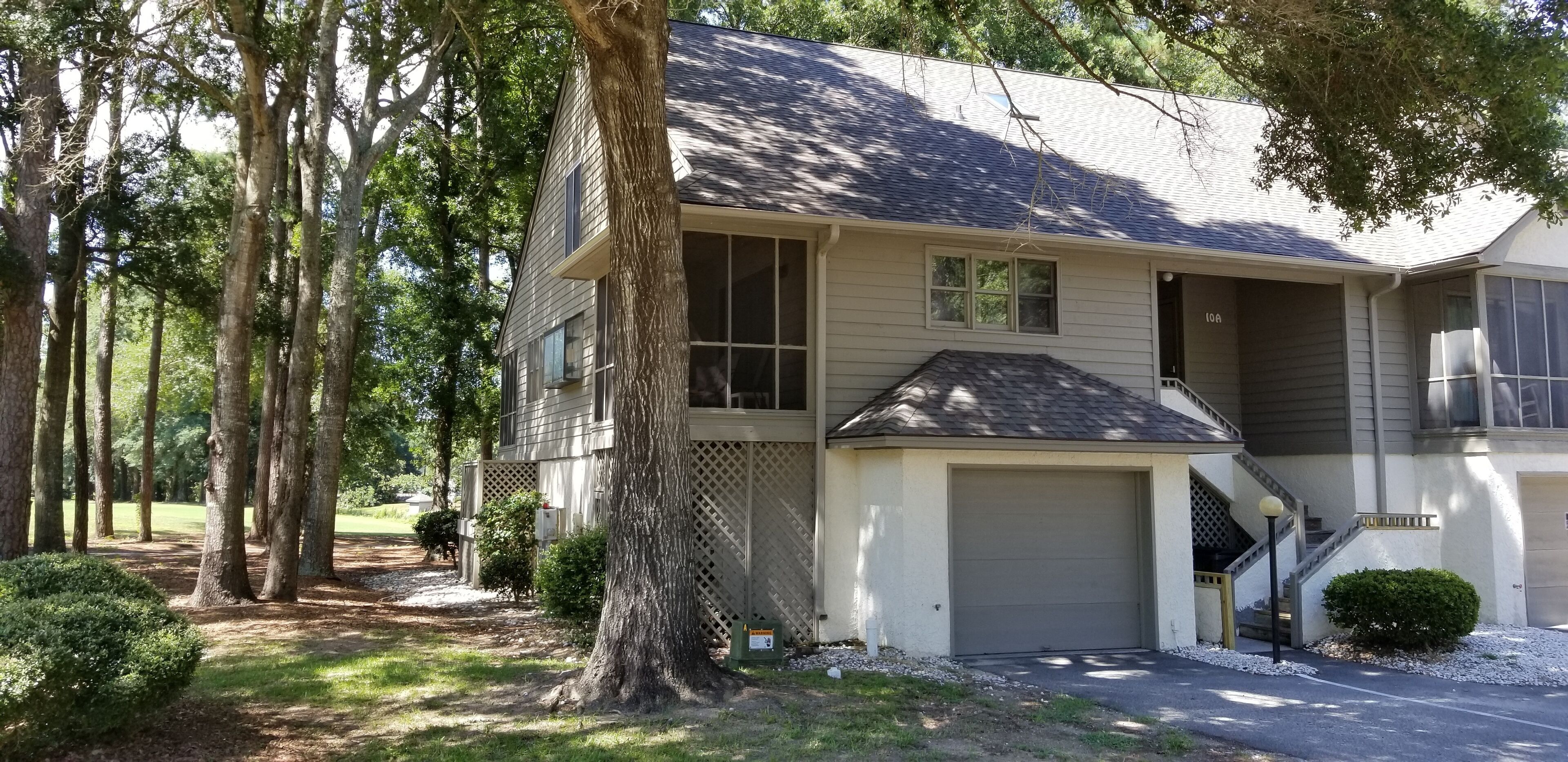 Une maison à deux étages avec un garage, une véranda et un escalier menant à l’étage supérieur.