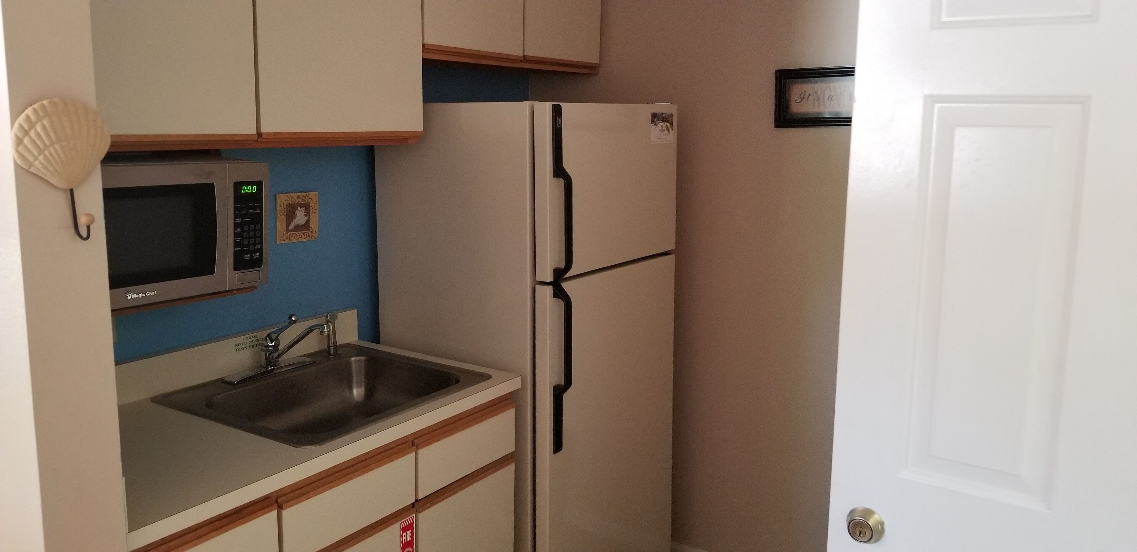 Eine kompakte Küche mit Mikrowelle, Spüle und Kühlschrank.