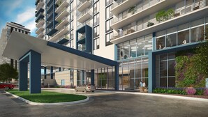 A modern multi-story building with a covered entrance, large windows, and a landscaped area with plants. - Downtown Doral #504 - Studio - 5350 Park (Doral)