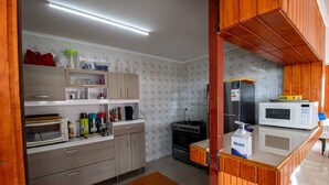 Moderni keittiö, jossa on puiset kaapit, mikroaaltouuni, liesi ja erilaisia keittiölaitteita.
