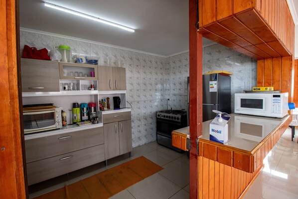A modern kitchen with wooden cabinets, a microwave, a stove, and various kitchen appliances.