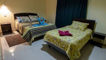 Habitación de hotel con dos camas, un tapete marrón y una mesita de noche.