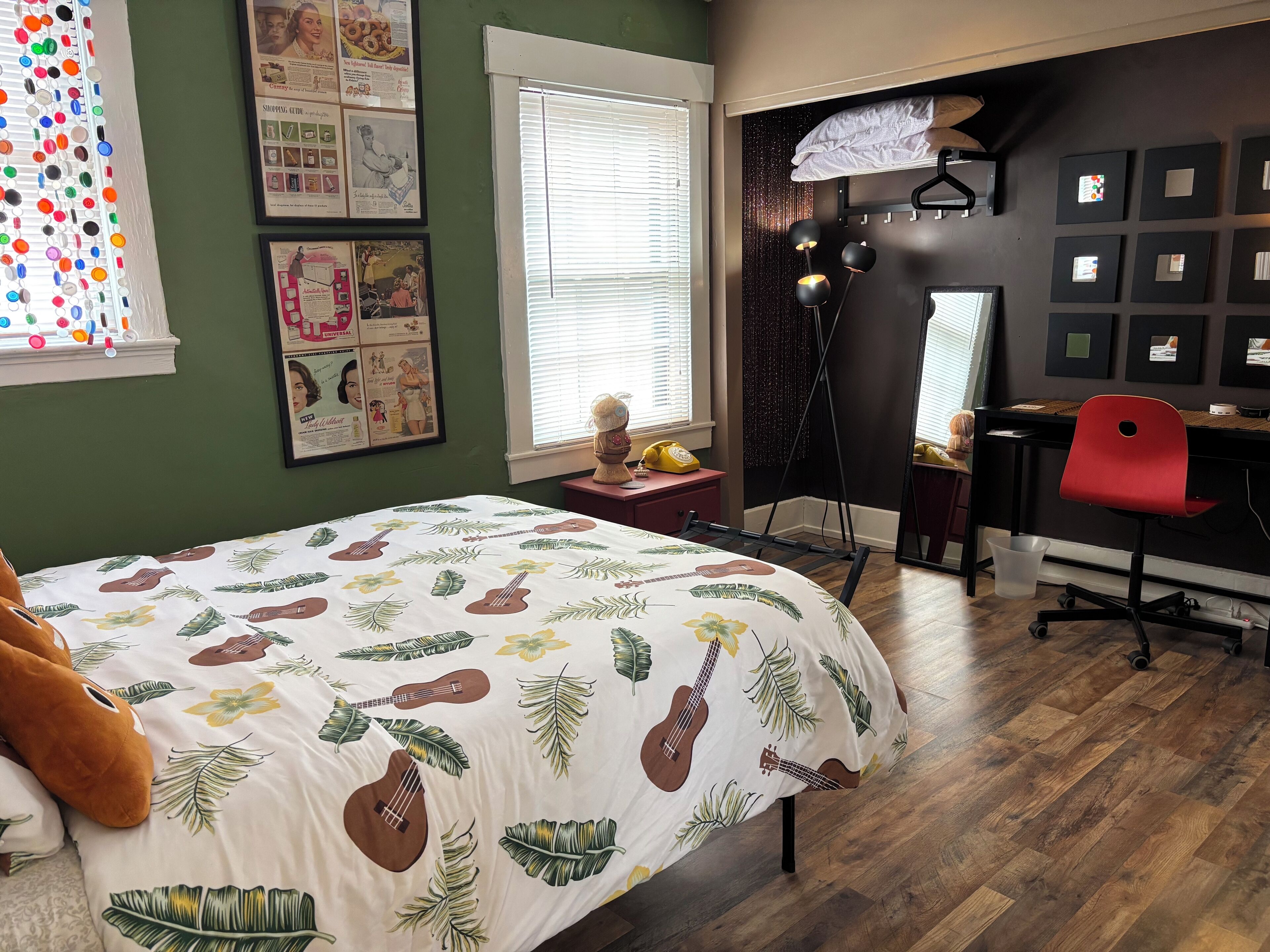 Une chambre à coucher comprenant un lit, un bureau, une chaise et une fenêtre avec des stores.