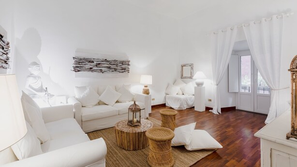 A white-themed living room with a sofa, two side tables, a lamp, and a decorative wall piece. - LUXURY HISTORIC APARTMENT (Roma)