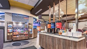A hotel lobby with a self-service kiosk, a coffee station, and a snack bar. - Tru by Hilton The Colony Dallas (The Colony)