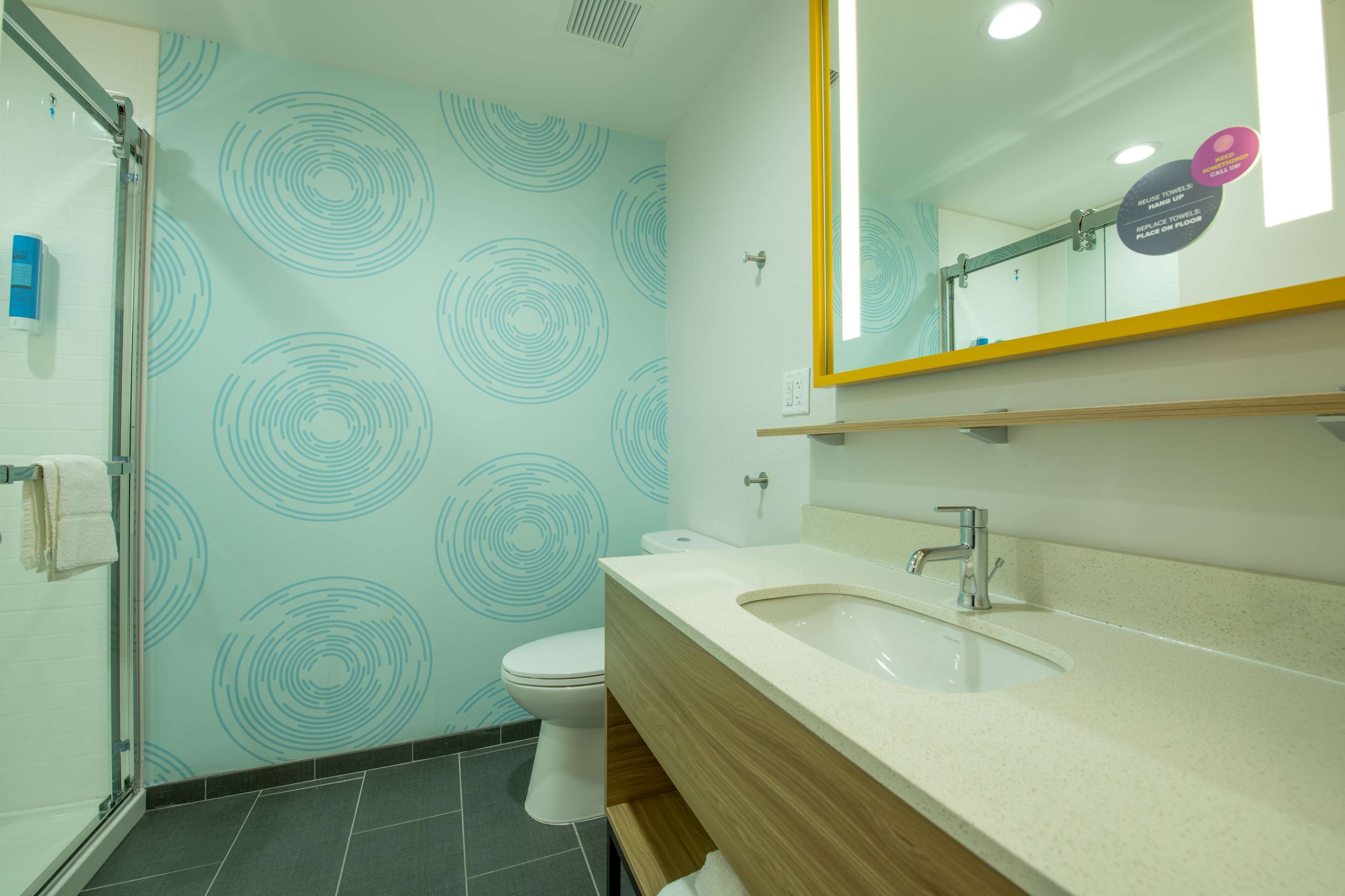 Un bagno moderno con il water, lavandino e doccia.