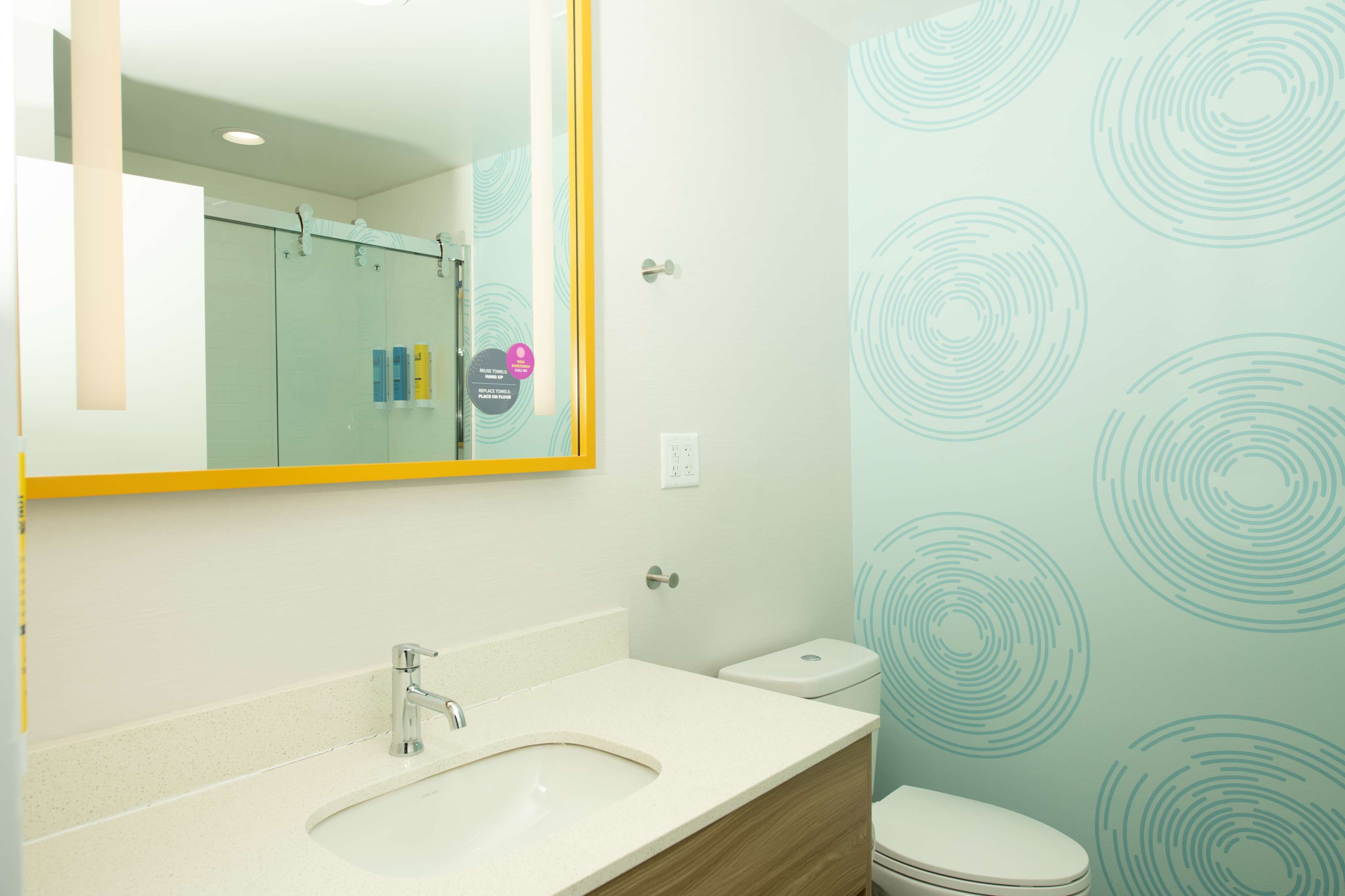 Ein Badezimmer mit Waschbecken, Spiegel und Toilette.