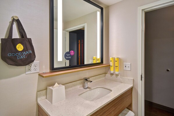 A bathroom with a sink, mirror, towel rack, and toiletries. - Tru by Hilton Manchester Downtown (Manchester)