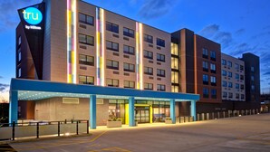 A modern hotel with a prominent 'tru by Hilton' sign, a covered entrance, and a parking area. - Tru by Hilton Manchester Downtown (Manchester)