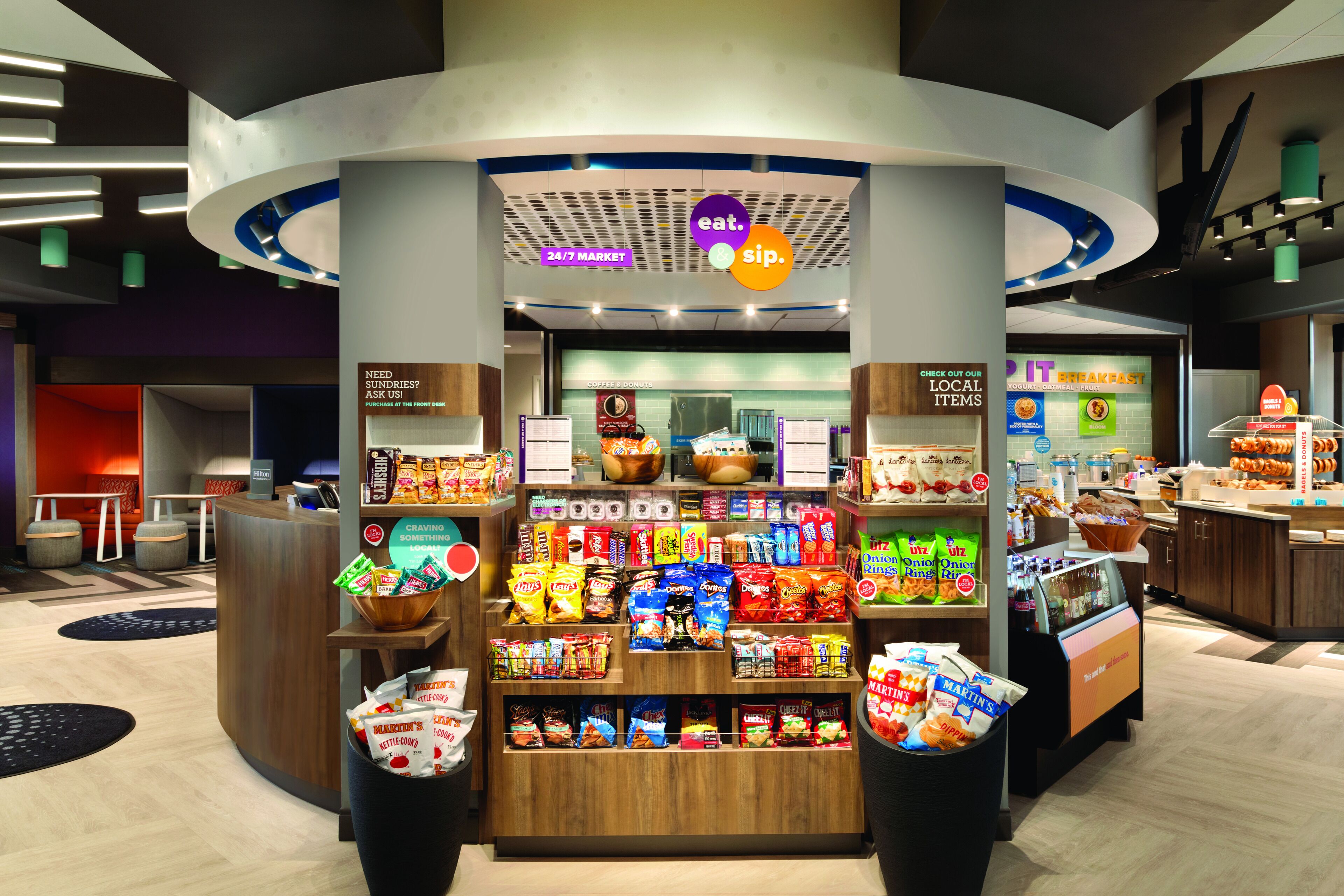 A 24/7 market with a variety of snacks and beverages, including chips and bottled drinks.