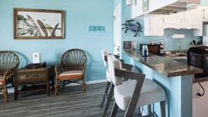 Uma cozinha moderna com área de bar, cadeiras de madeira e mesa de jantar.