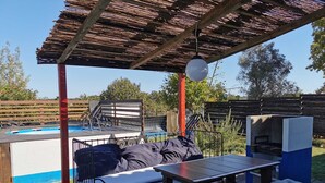 An outdoor patio with a pool, a wooden table, a bench, and a grill. - Herdade Palma T1  (country house) (Moita)