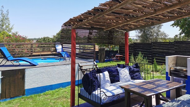 A covered outdoor area with a pool, lounge chairs, a barbecue grill, and a seating area with cushions. - Herdade Palma T1  (country house) (Moita)