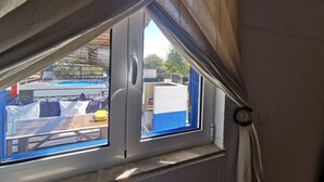 A window with a view of a pool area, including a pool table and outdoor seating. - Herdade Palma T1  (country house) (Moita)