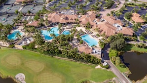 Eine Luftaufnahme eines Resorts mit mehreren Schwimmbecken, einem Golfplatz und einem Parkplatz.
