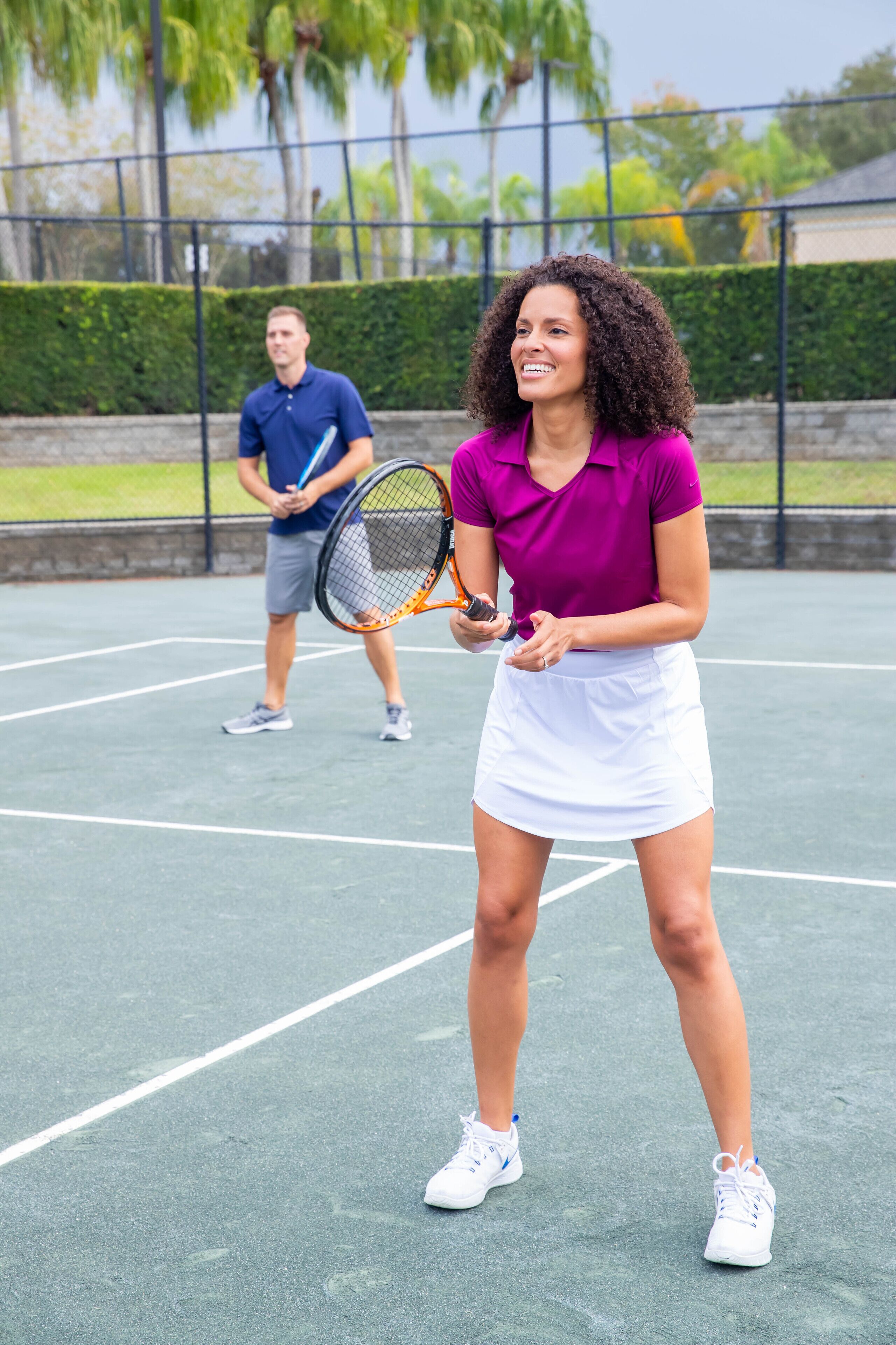 A tennis court with two players, one holding a racket.