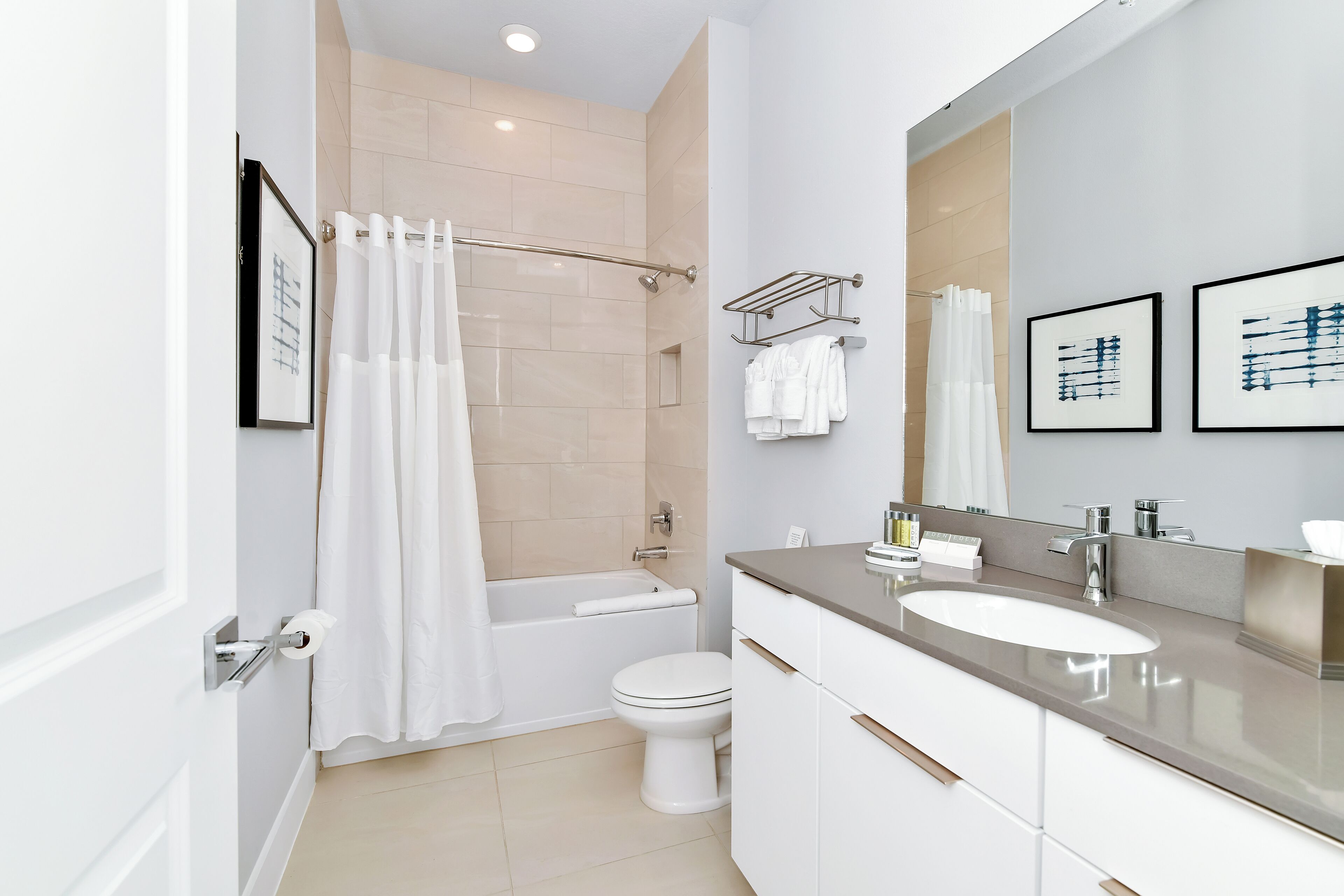 A modern bathroom with a bathtub, toilet, and vanity with a sink.