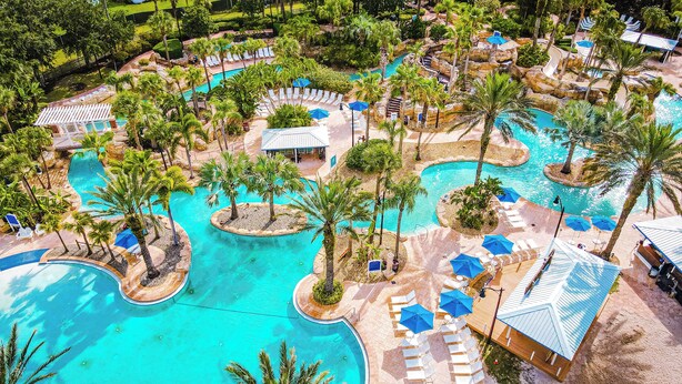 A resort with multiple swimming pools, palm trees, and lounge areas. - Spectrum Resort Villas Orlando and Waterparks (Kissimmee)