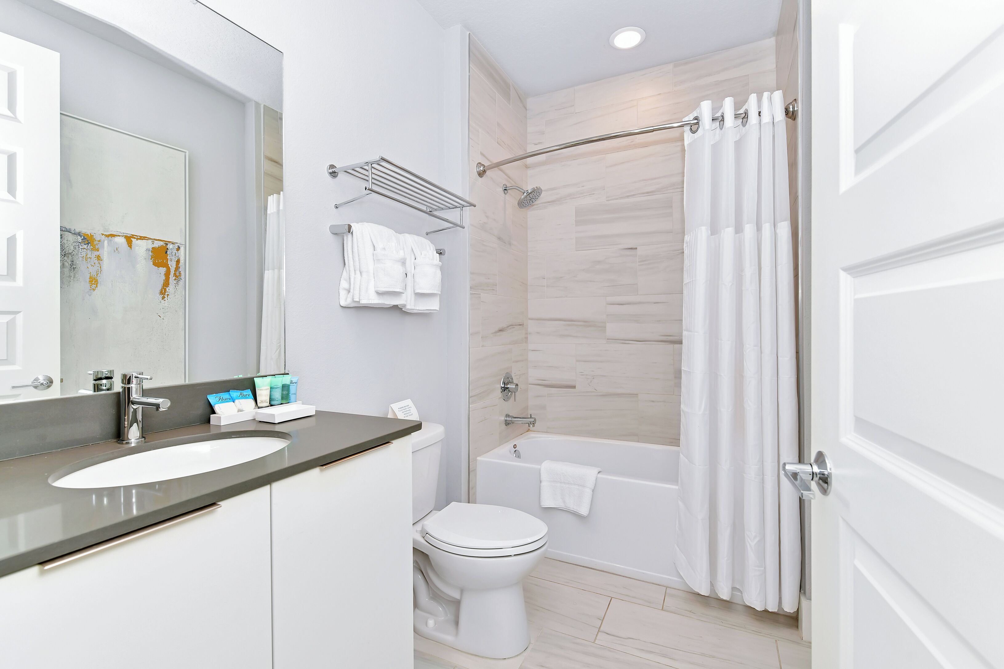 Une salle de bain moderne équipée d’un lavabo, de toilettes, d’une douche et d’une baignoire.