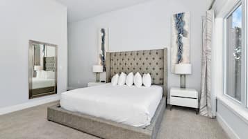 A modern bedroom with a large bed, two nightstands, a mirror, and abstract wall art.