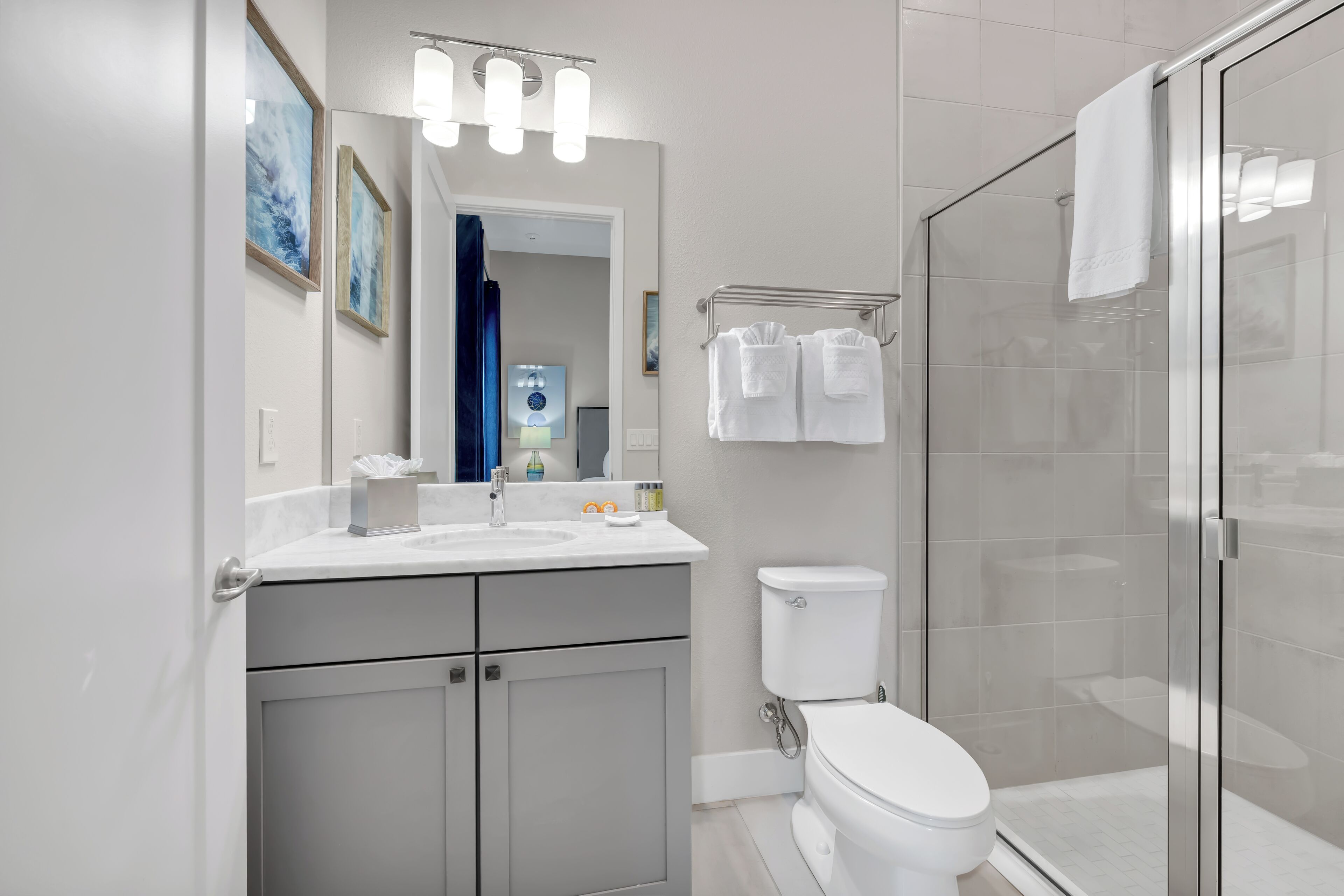 Une salle de bain moderne équipée d’une douche, de toilettes et d’un meuble-lavabo.