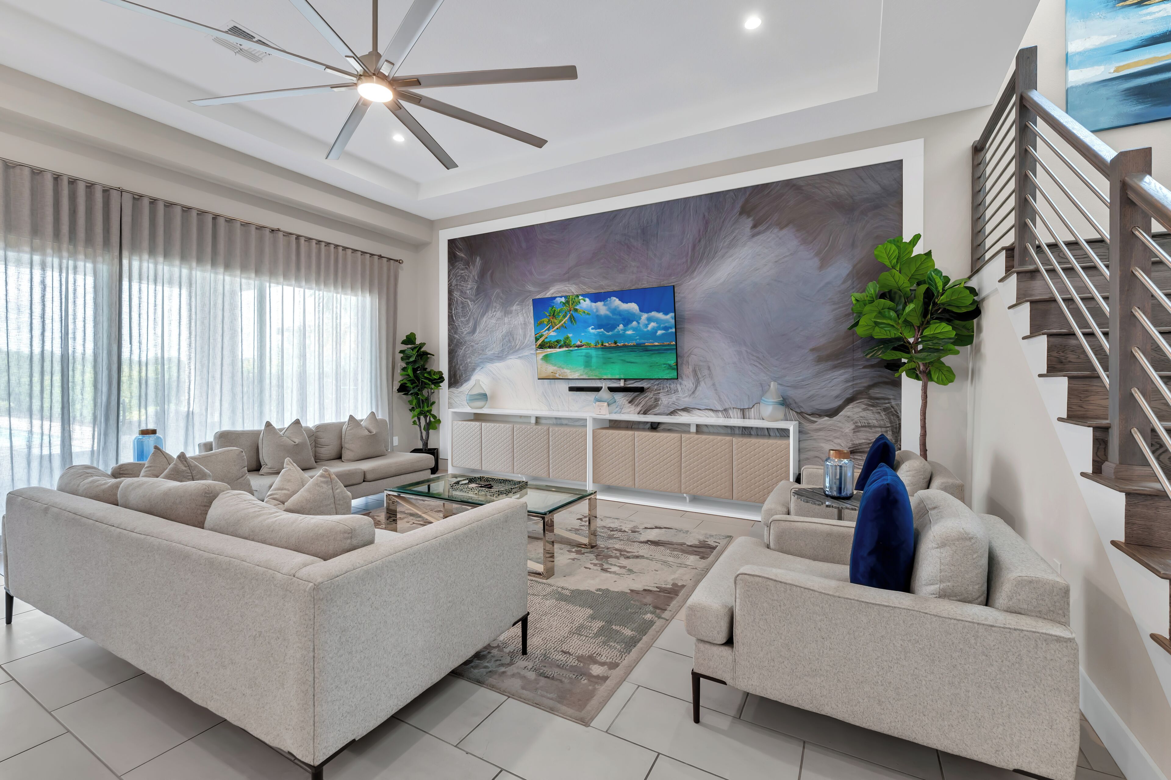 A modern living room with a sofa, coffee table, and a TV mounted on a textured wall.