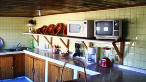 Una cocina con armarios de madera, un microondas, un tostador y una cafetera sobre la encimera.
