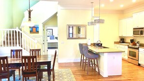 A spacious kitchen with a central island, wooden dining table, and chairs. - Beautiful Cottage on Hilton Head Island, Blue (Hilton Head Island)