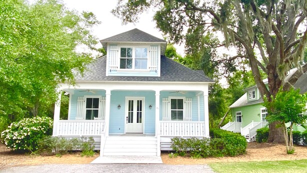 A two-story house with a front porch, a small front yard, and a tree with hanging moss. - Beautiful Cottage on Hilton Head Island, Blue (Hilton Head Island)