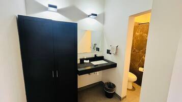 Een moderne badkamer met een zwarte kast, een wastafel, een spiegel en een toilet.