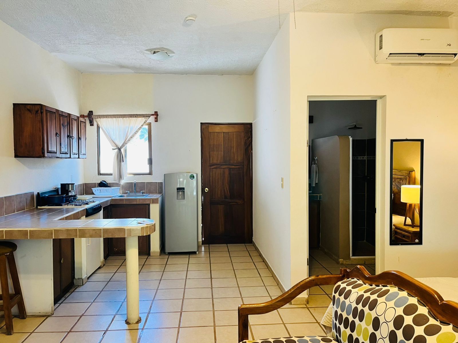 Una cocina compacta con refrigerador, pileta y muebles de madera.