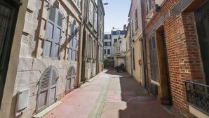 A narrow alleyway between buildings with a motorcycle parked in the distance.