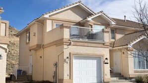 A two-story house with a balcony, a garage, and a well-maintained lawn. - Paradise Canyon Golf Resort - Luxury Condo M403 (Lethbridge)