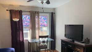 A room with a TV on a cabinet, a table with a chair, a ceiling fan, and a window with curtains. - Cozy and fresh one-bedroom, 10 minutes from Old Town Alexandria (Alexandria)