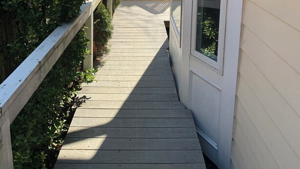 A wooden deck leading to a house with a white exterior and a large window. - Cozy and fresh one-bedroom, 10 minutes from Old Town Alexandria (Alexandria)