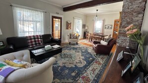 Un salon comprenant un canapé, un fauteuil, une table basse et un coin repas avec une table et des chaises.