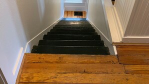 Un escalier menant à un palier doté d’une petite fenêtre.