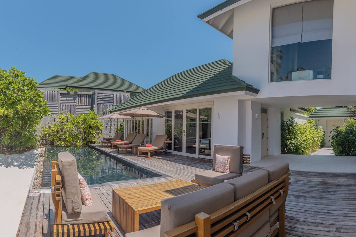 A modern resort with a pool area, outdoor seating, and a covered patio.