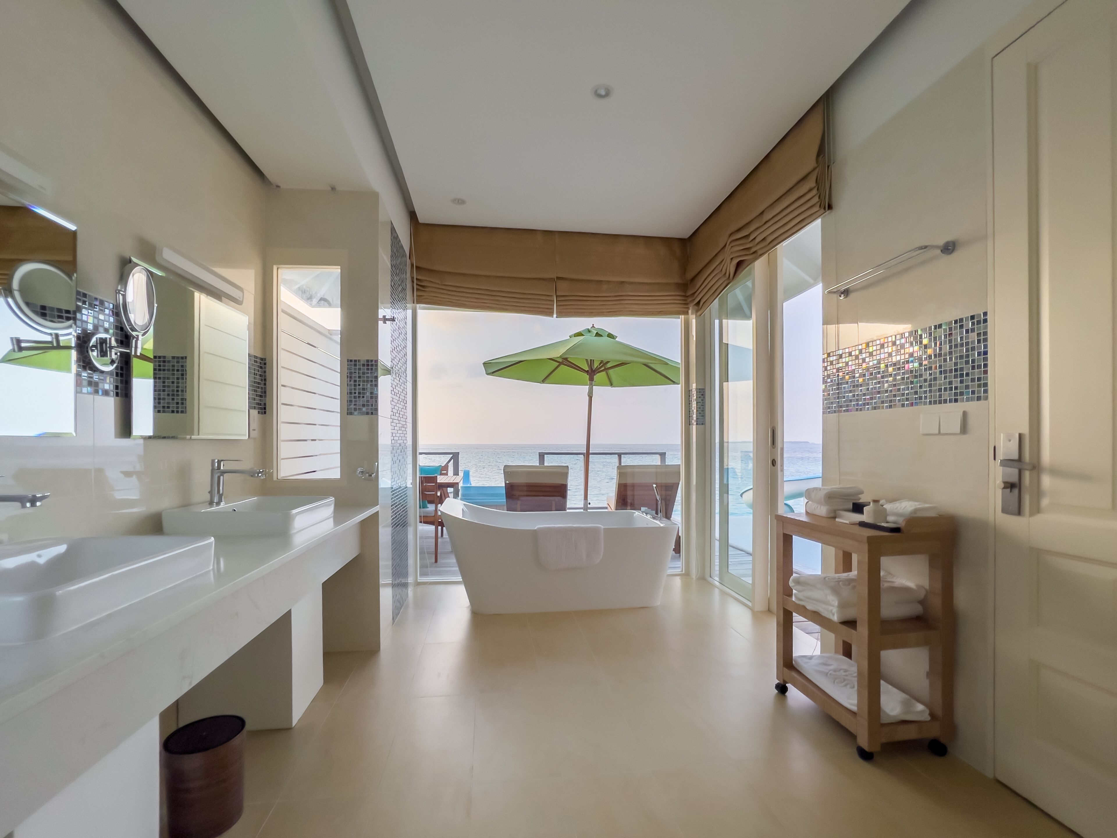 A modern bathroom with a large bathtub, a vanity with a mirror, and a shower area.