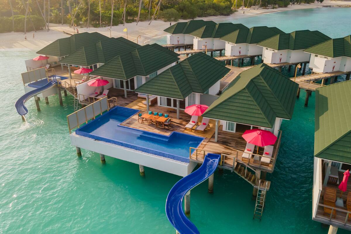 Overwater bungalows with a pool, slides, and beach access.