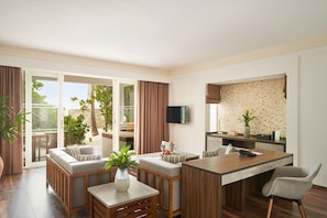 A modern living room with a sofa, a coffee table, and a dining area with a wooden table and chairs.