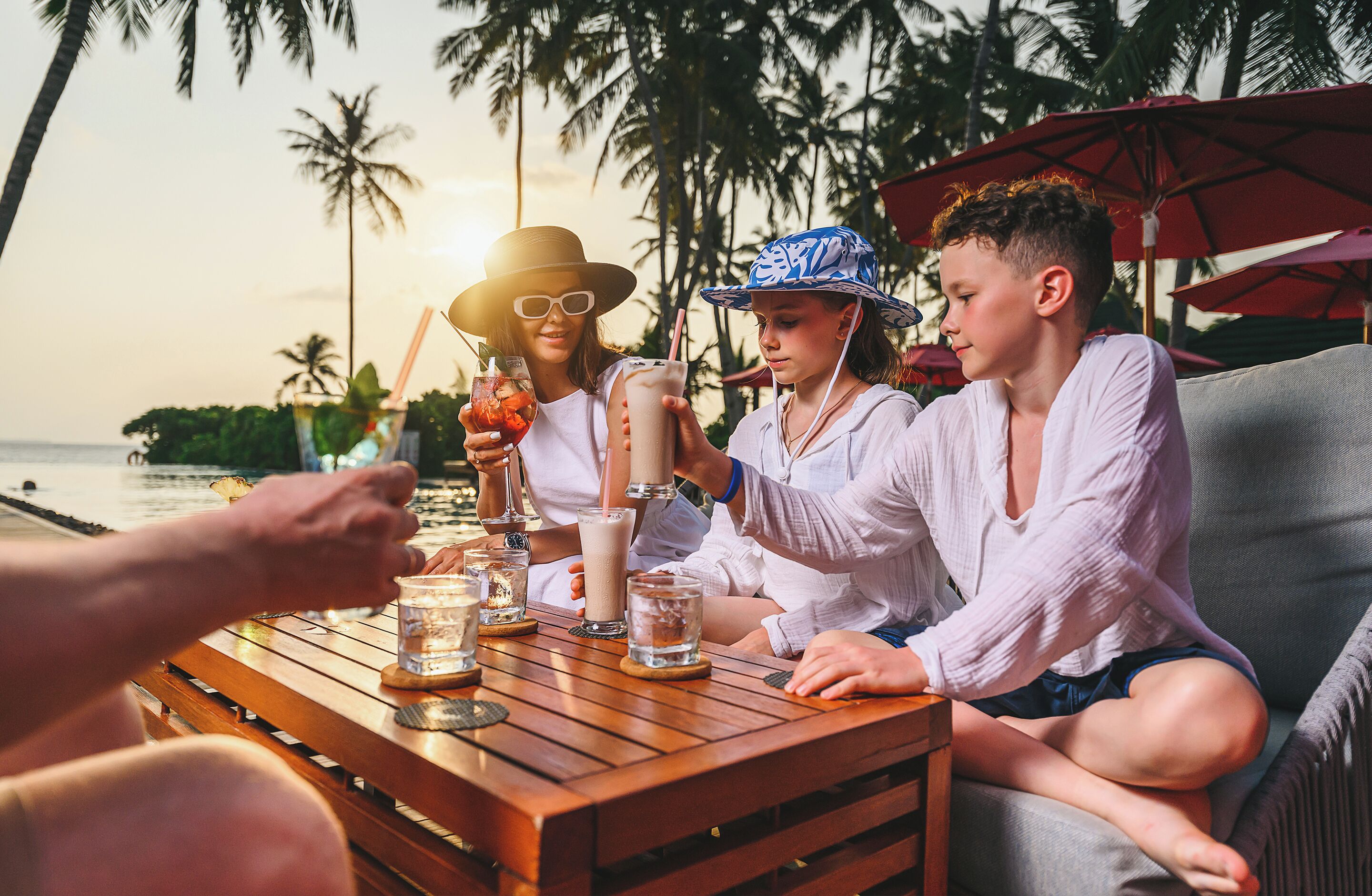 Une table en bois avec des boissons et un verre d’eau.