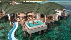 An overwater villa with a swimming pool, lounge area, and a slide. - Siyam World Maldives - All-inclusive  (Dhigurah)