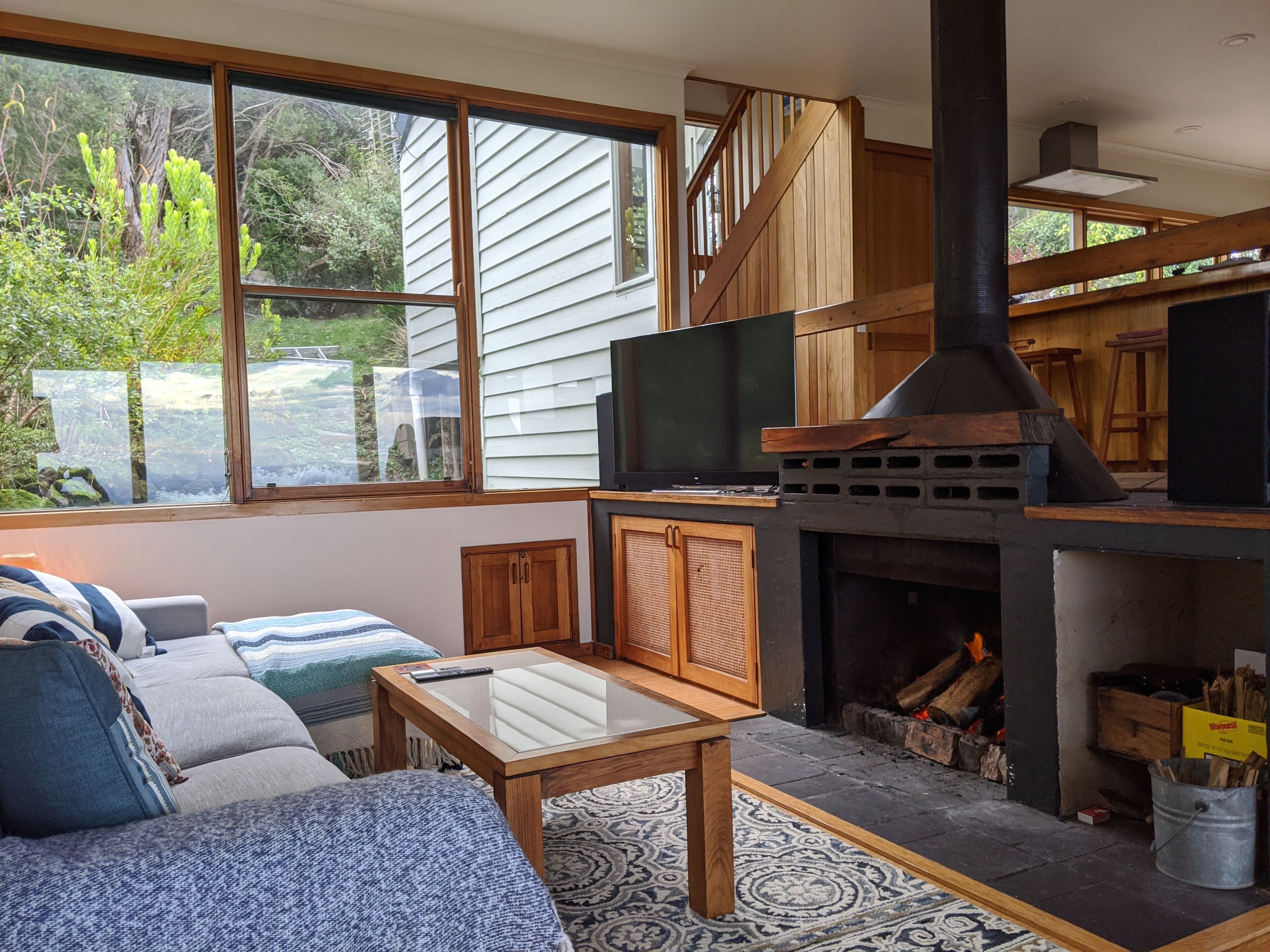 A cozy living room with a fireplace, a sofa, a coffee table, and a TV.